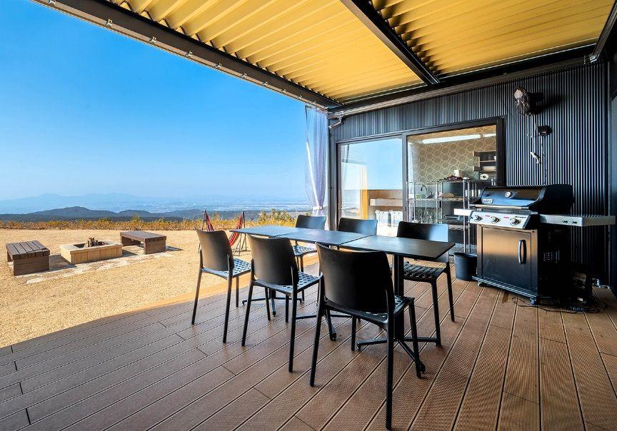 写真：グランピング棟のテラスと焚き火スペース