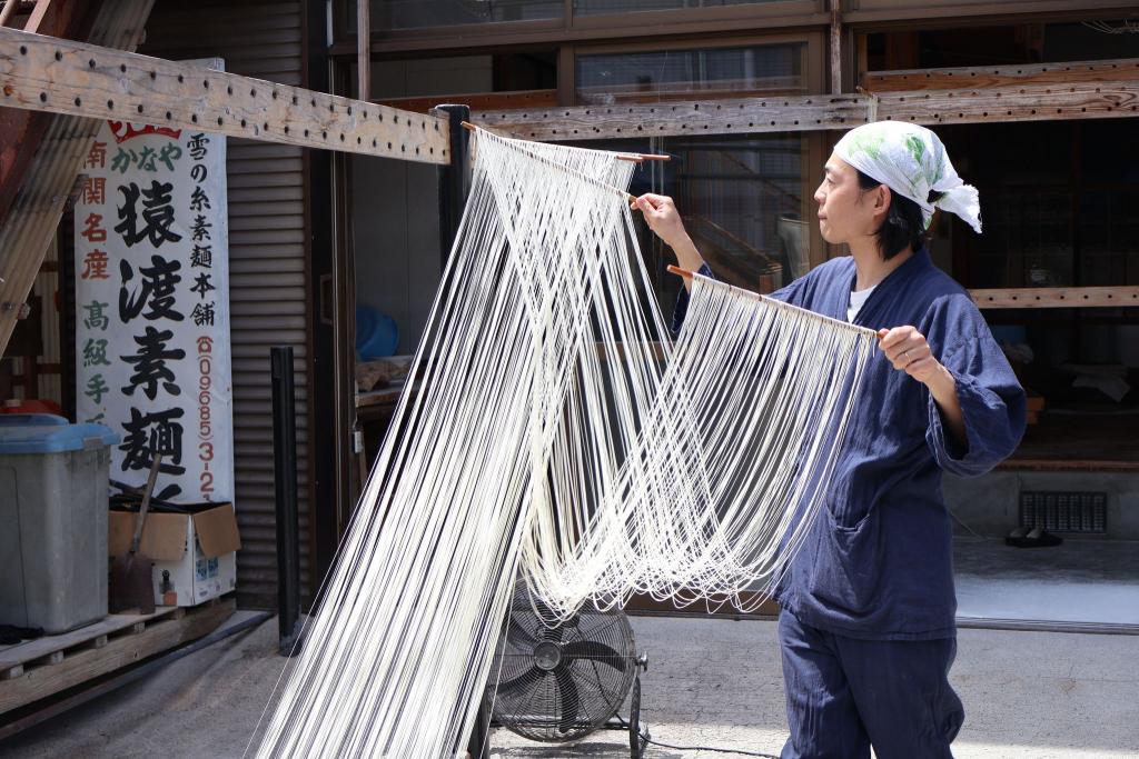 写真：素麺づくりの工程。屋外の物干しにそうめんをかけている様子
