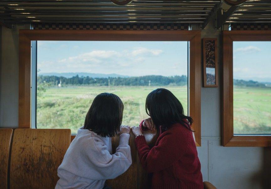 写真：車内から景色を見る乗客