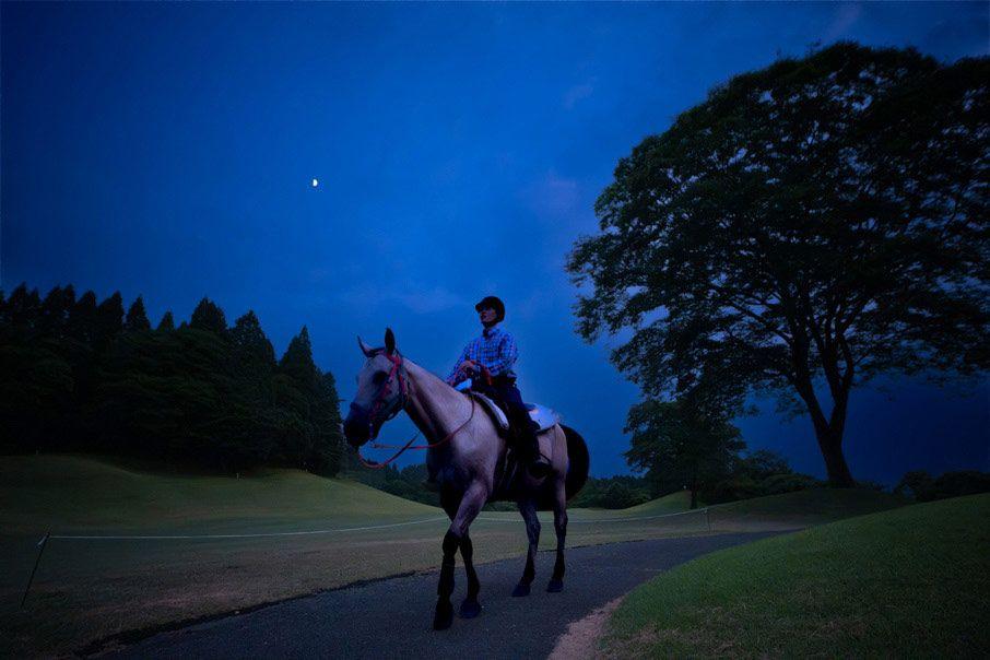 夜の暗闇の中で乗馬する様子の写真