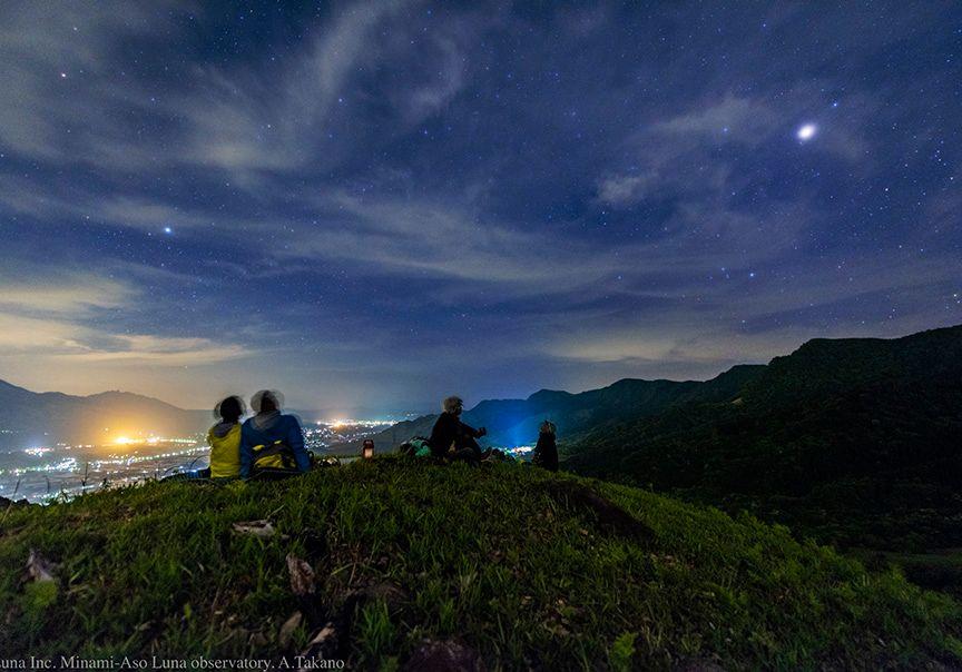 山の頂上で参加者がくつろぐ様子の写真