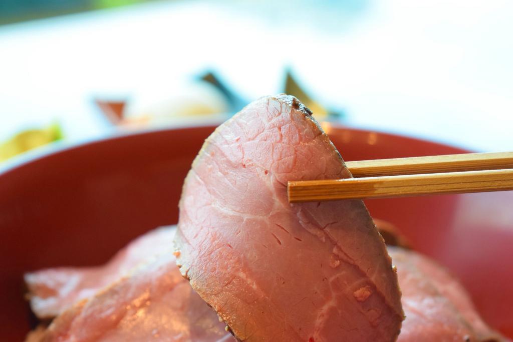 あか牛の切り身を箸で持ち上げている写真