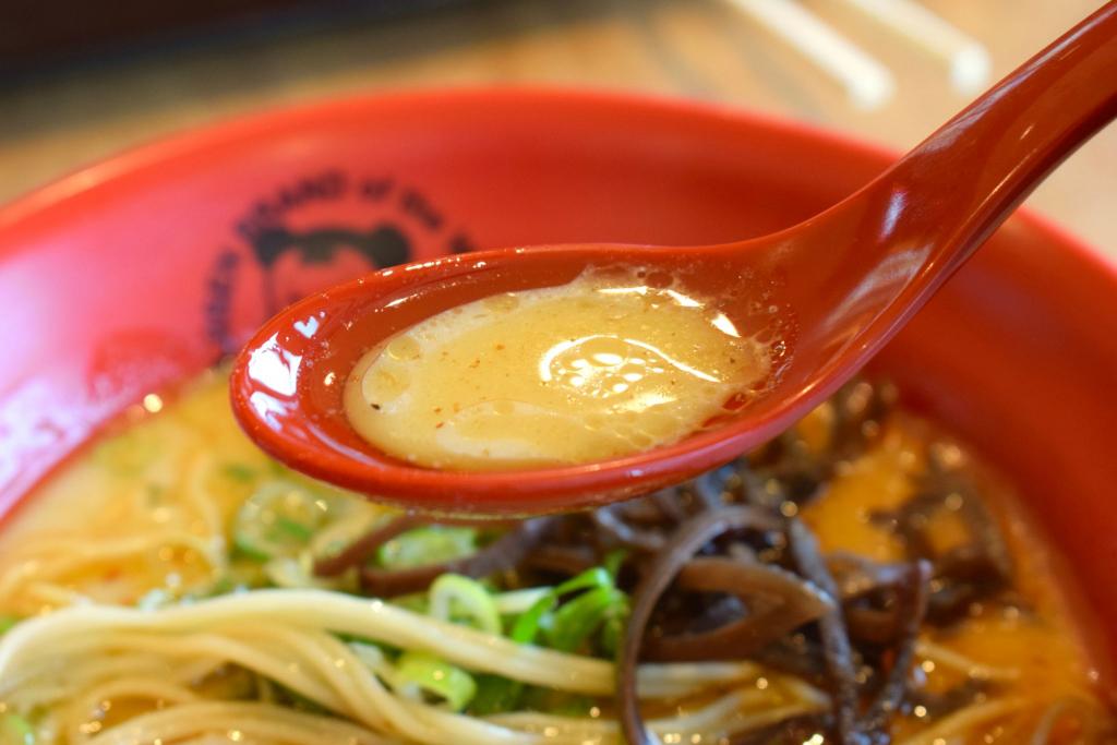 味千ラーメンのスープをレンゲですくって持ち上げている写真