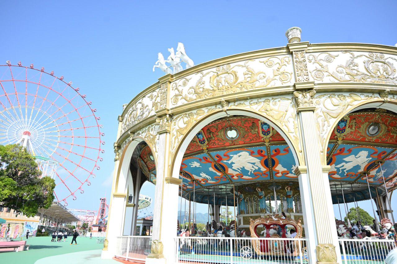 写真:メリーゴーランドの後ろには大きな観覧車も