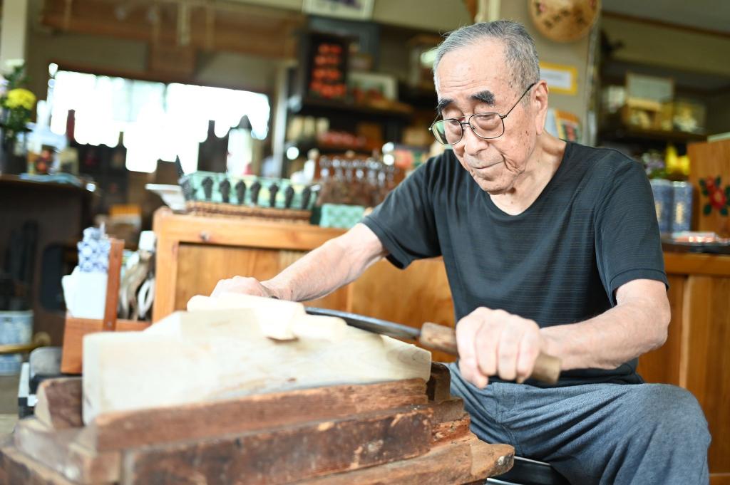 写真：きじ馬のお腹側の面取りを行う忠嘉さん