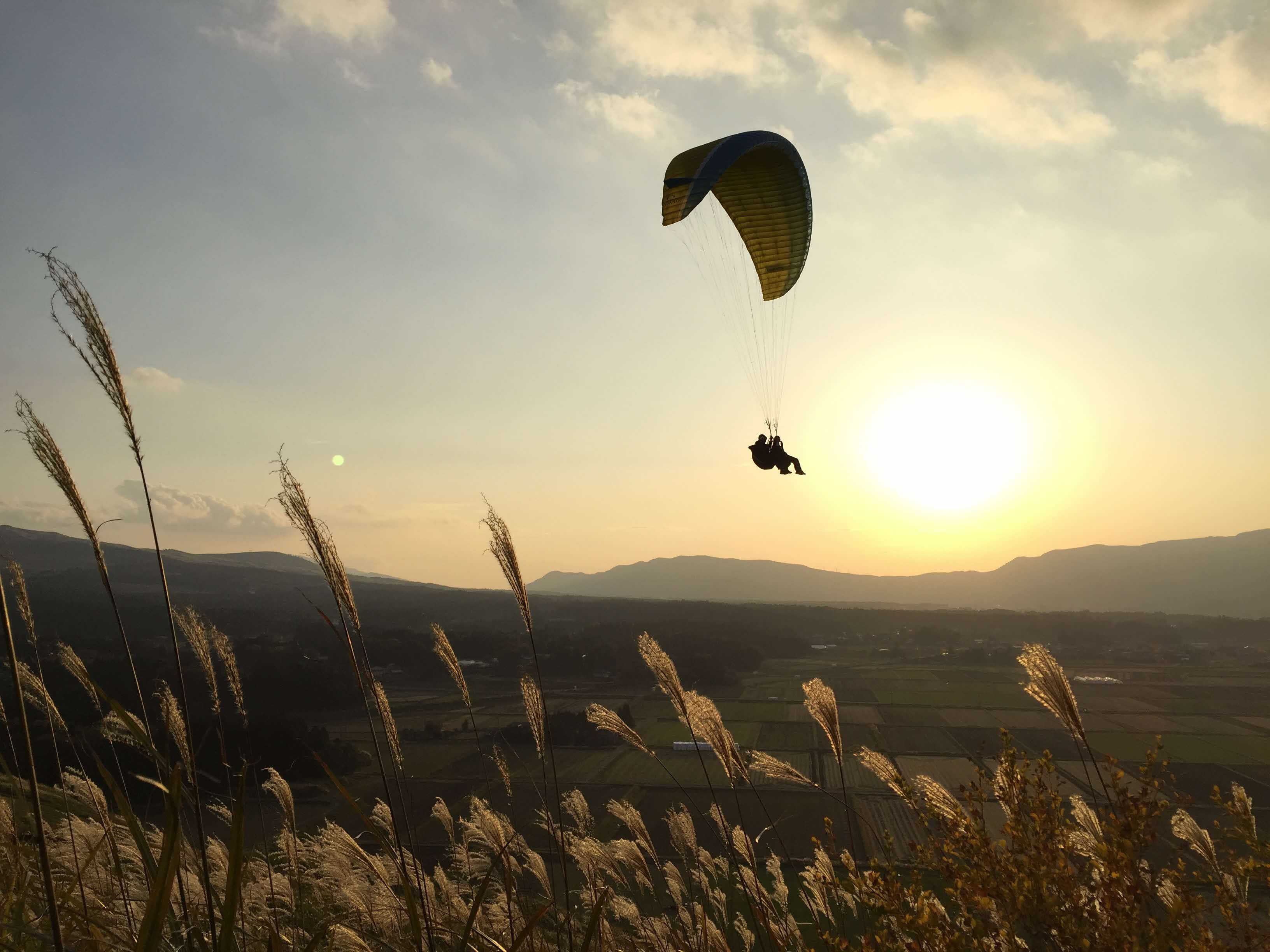 Paragliding over the Aso caldera at sunset