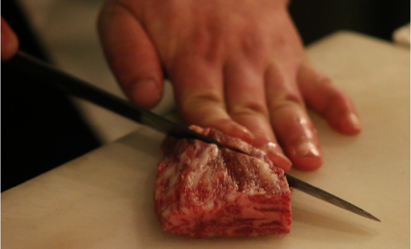 薪と炭で牛肉を焼く宮本シェフ